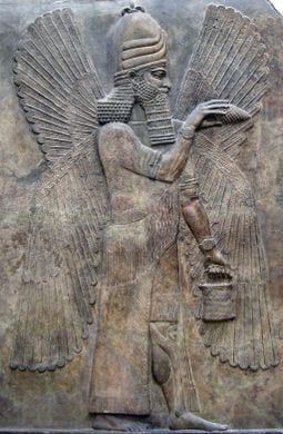 An Assyrian stone relief of a winged deity